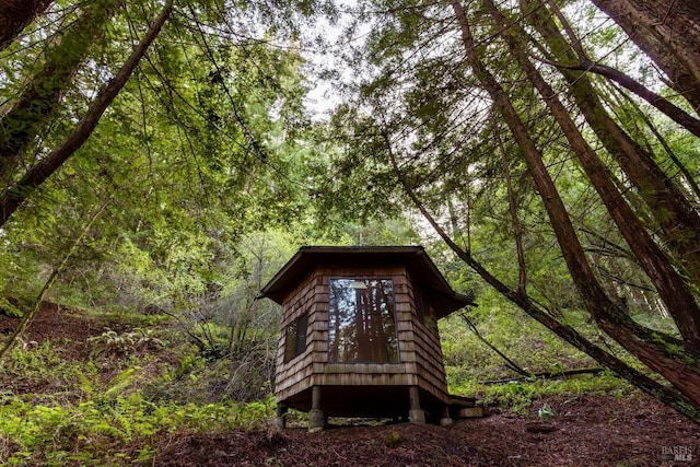 exterior space featuring an outbuilding and a wooded view