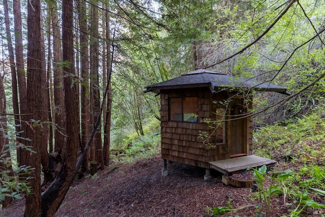 view of shed with a forest view