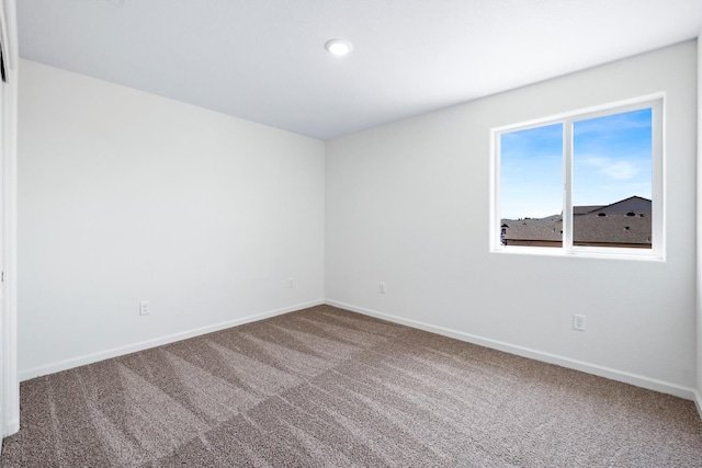 unfurnished room featuring baseboards and carpet floors