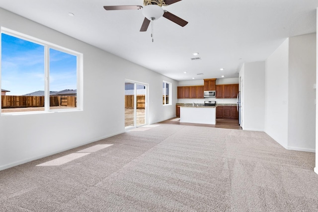unfurnished living room featuring light carpet, baseboards, a ceiling fan, and recessed lighting