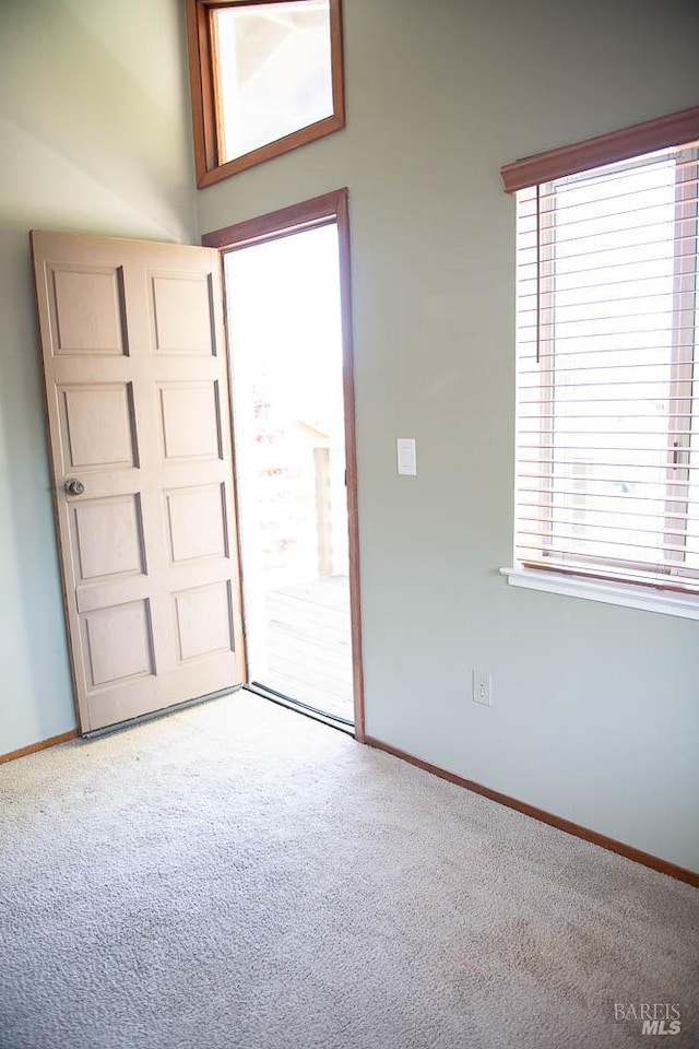 carpeted spare room featuring baseboards