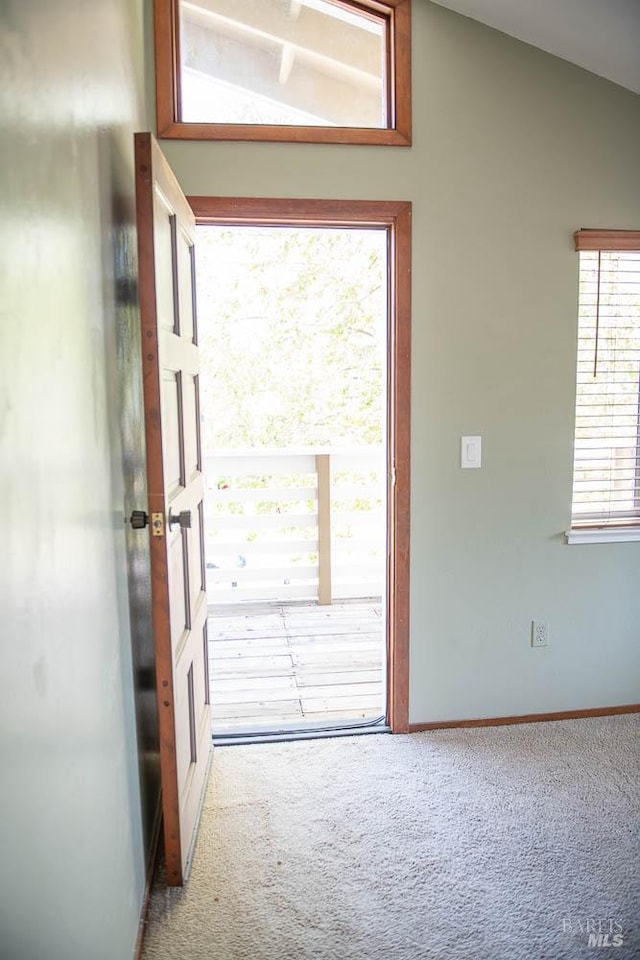 entryway featuring baseboards, carpet floors, and lofted ceiling