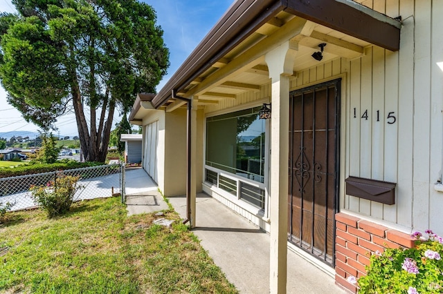 property entrance with fence and board and batten siding
