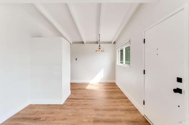 unfurnished dining area with light wood-type flooring, lofted ceiling with beams, and baseboards