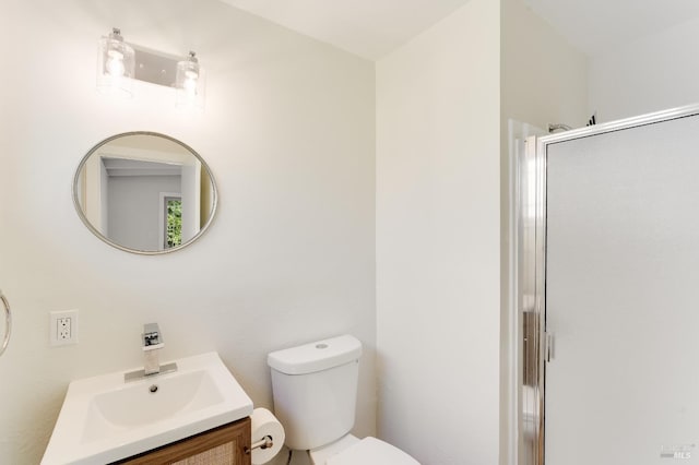 bathroom with toilet, a shower stall, and vanity