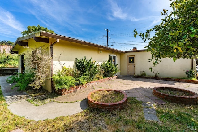 rear view of property with a patio area and stucco siding
