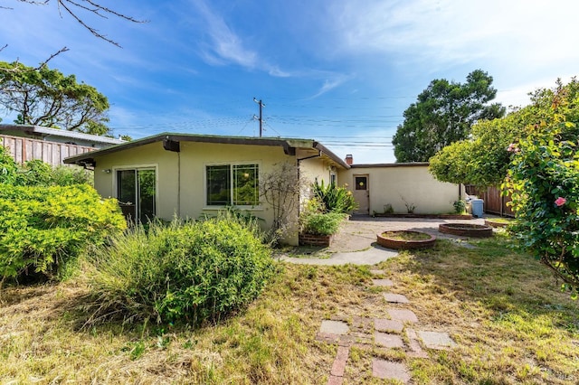rear view of property with fence and stucco siding