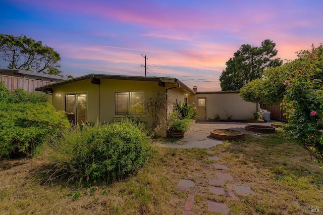 back of house featuring fence and stucco siding