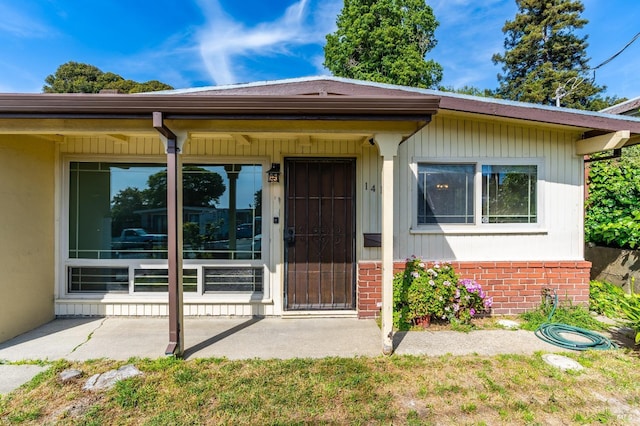 doorway to property with brick siding