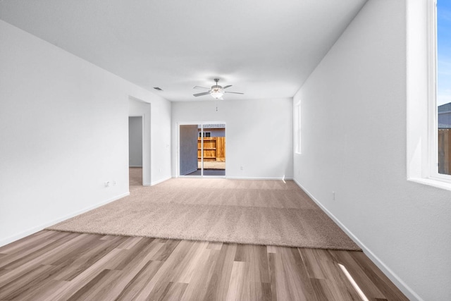 empty room featuring wood finished floors, ceiling fan, and baseboards