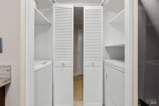 washroom with washer and clothes dryer, light wood-type flooring, and laundry area