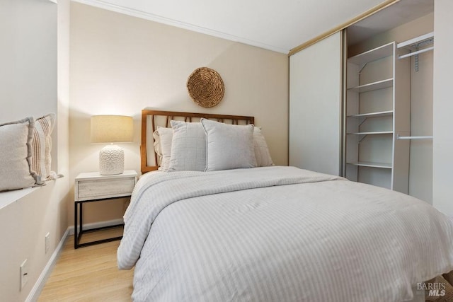 bedroom with baseboards, wood finished floors, and crown molding