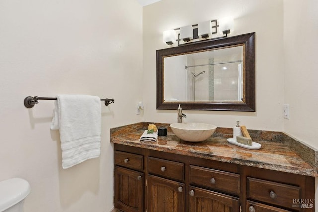 bathroom featuring vanity, toilet, and tiled shower