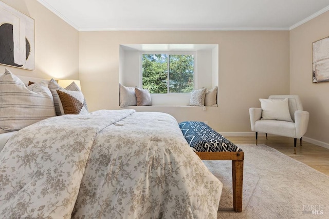 bedroom with crown molding, baseboards, and wood finished floors