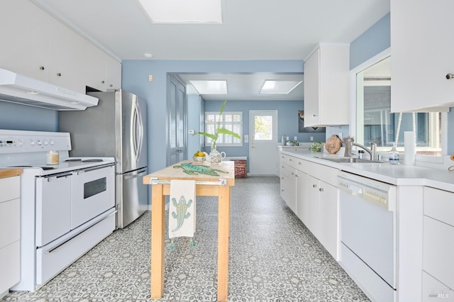 2 Beach Rd, Belvedere, CA 94920 - kitchen featuring white appliances, under cabinet range hood, a sink, light countertops, and white cabinets