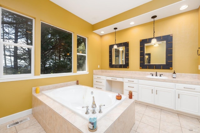 bathroom with tile patterned flooring, vanity, a healthy amount of sunlight, a tub with jets, and visible vents