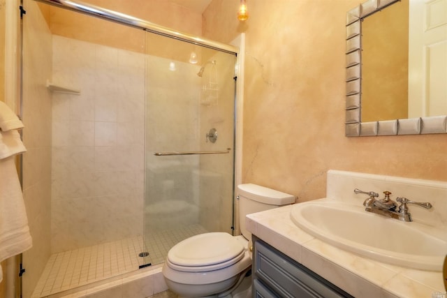 bathroom with a stall shower, a textured wall, toilet, and vanity