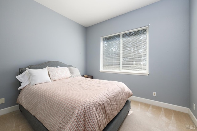 bedroom with baseboards and light colored carpet