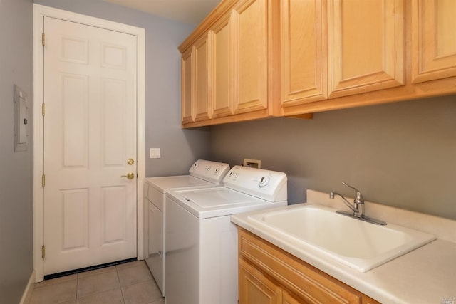 laundry area featuring washing machine and clothes dryer, cabinet space, a sink, and light tile patterned flooring