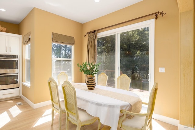 dining space featuring light wood-style flooring, baseboards, and recessed lighting