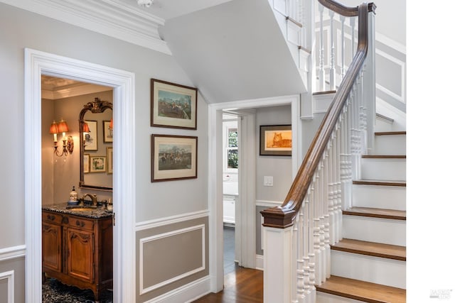 stairs featuring wet bar and ornamental molding