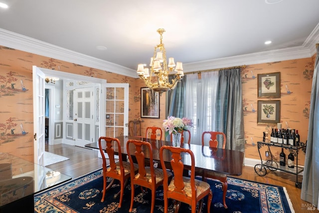 dining area with crown molding, wallpapered walls, wood finished floors, and a notable chandelier