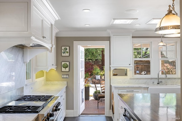 kitchen with plenty of natural light, a sink, high end stainless steel range oven, and white cabinets