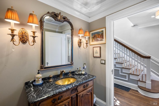 bathroom with vanity, ornamental molding, baseboards, and wood finished floors