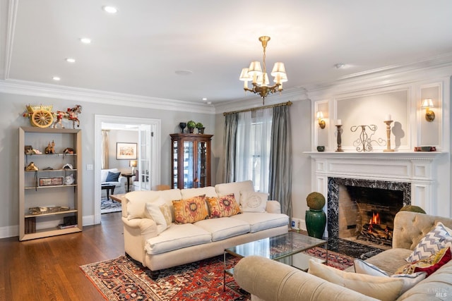 living area with crown molding, recessed lighting, a high end fireplace, dark wood finished floors, and a notable chandelier