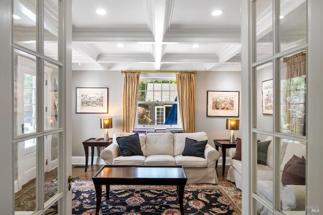 interior space with baseboards, ornamental molding, beam ceiling, and wood finished floors