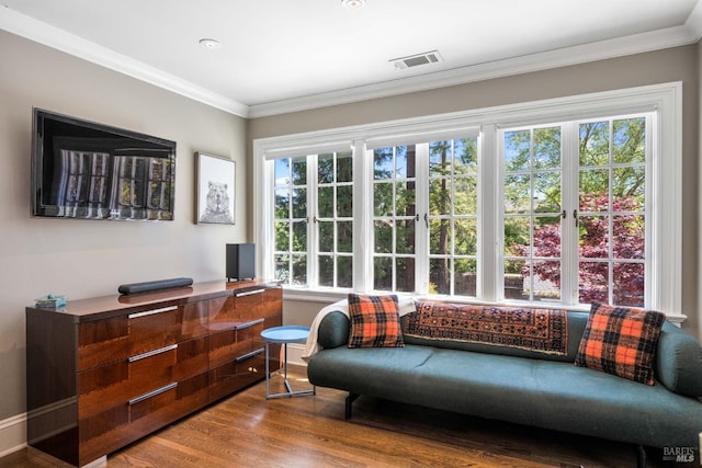 sitting room with visible vents, ornamental molding, and wood finished floors