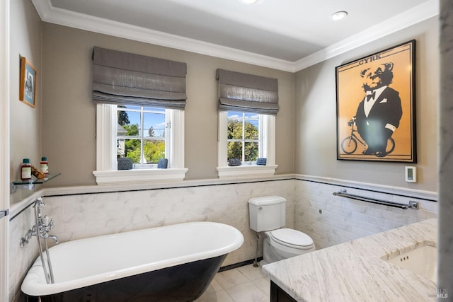full bath featuring vanity, crown molding, a freestanding tub, tile patterned flooring, and tile walls