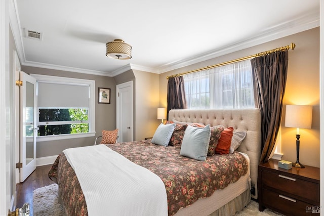 bedroom featuring crown molding, baseboards, and wood finished floors