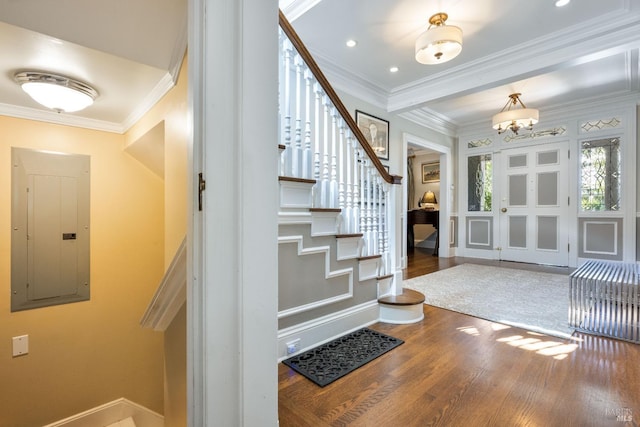 foyer with baseboards, stairs, wood finished floors, and electric panel
