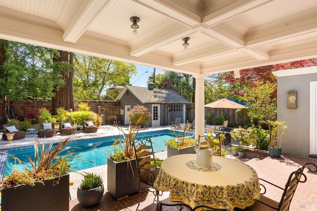 view of pool featuring a storage structure, a fenced in pool, an outdoor structure, a fenced backyard, and a patio