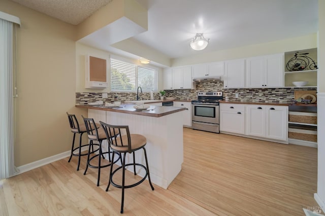 kitchen with stainless steel electric range oven, a breakfast bar, a sink, open shelves, and light wood-style floors