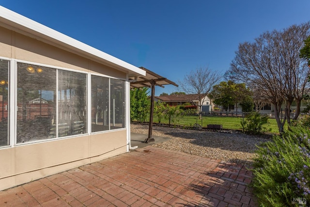 view of patio with a sunroom and fence