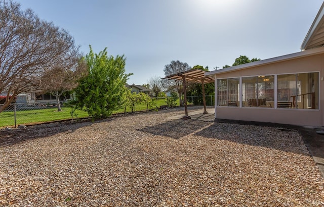view of yard with a pergola, a sunroom, fence, and a patio