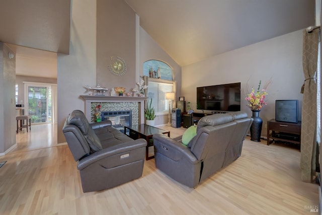 living area with high vaulted ceiling, baseboards, wood finished floors, and a fireplace