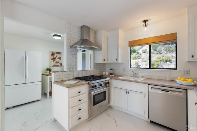 kitchen with a sink, appliances with stainless steel finishes, wall chimney exhaust hood, marble finish floor, and backsplash
