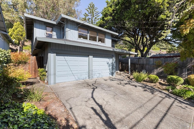 garage with fence and driveway