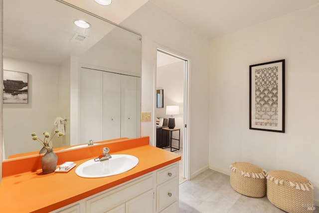 bathroom featuring vanity, recessed lighting, and baseboards