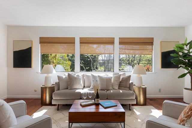 living area with baseboards, light wood-type flooring, and a fireplace