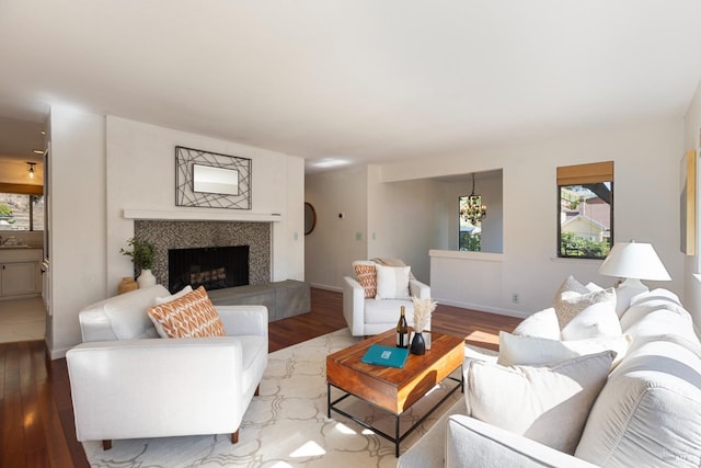 living room featuring a fireplace, wood finished floors, and baseboards