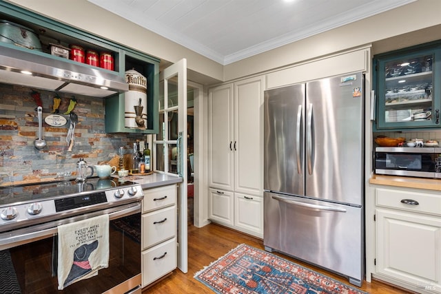 kitchen with light wood finished floors, stainless steel appliances, white cabinets, decorative backsplash, and crown molding