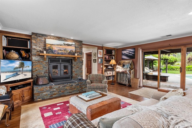 living room with ornamental molding, a wood stove, and a textured ceiling
