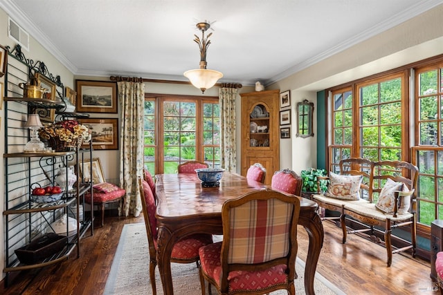 dining room featuring wood finished floors, visible vents, and crown molding