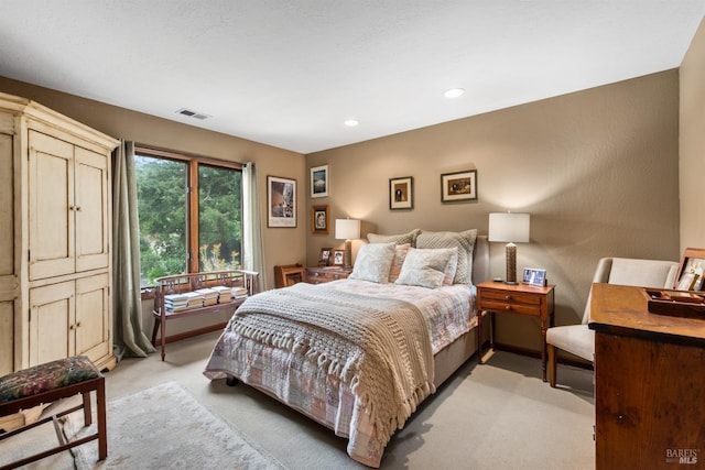 bedroom with light colored carpet, visible vents, and recessed lighting