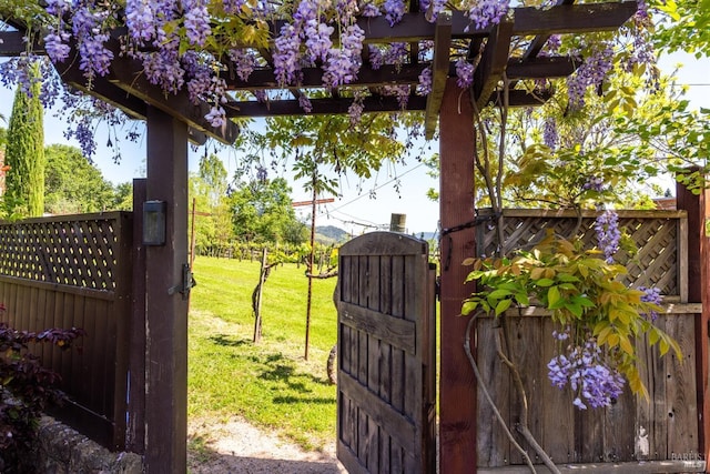 view of gate featuring fence and a yard