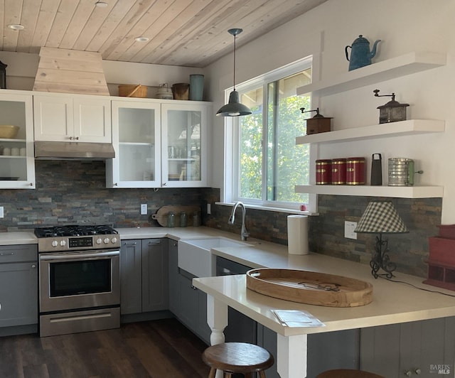 kitchen featuring under cabinet range hood, wood ceiling, stainless steel range with gas stovetop, and light countertops
